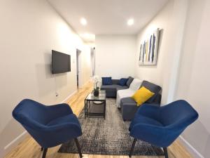 - un salon avec un canapé et deux fauteuils bleus dans l'établissement Lumineux et magnifique logement proche du Jardin Botanique, à Montréal