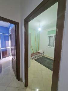 um quarto com uma porta que leva a um quarto com uma janela em appart near the Airport and beach Tanger gzenaya 2 rooms em Tânger