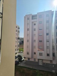un bâtiment rose à côté d'un bâtiment blanc dans l'établissement appart hotel tanger gzenaya, à Tanger