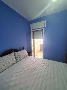 um quarto com uma cama com uma parede azul em appart near the Airport and beach Tanger gzenaya 2 rooms em Tânger mais 12 fotografias