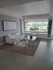 sala de estar con sofá, mesa y sillas en Apartamento en Torre Del Plata II, en Punta del Este