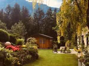 a garden with a wooden cabin in the background at Haus Nardin in Spital am Pyhrn