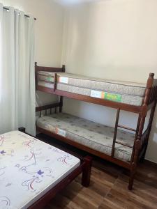 two bunk beds in a room with a bed at Casa com piscina para temporada - Unamar, Cabo Frio - RJ in Cabo Frio