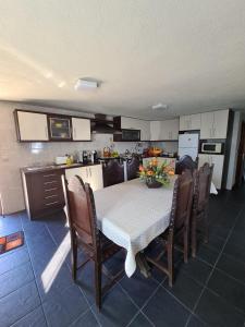 una cucina con tavolo e alcune sedie e una cucina con tavolo di Casa dos Pinheiros - Serra da Estrela a Penhas da Saúde