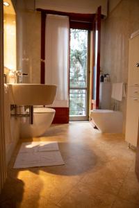 uma casa de banho com um lavatório, um WC e uma janela. em Casa Giuly em Parma