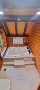 a large bath tub sitting inside of a room at Ecos da Terra Chalés in Monte Verde +95 photos