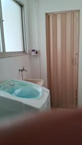 baño con lavabo y aseo y ventana en Apartamento Guarapari Praia Castanheiras, en Guarapari