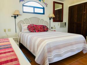 - une chambre avec un grand lit blanc et des oreillers rouges dans l'établissement 10 Minute Walk to Pickleball and the Sea of Cortez, à Los Barriles