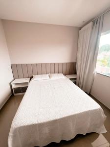 een slaapkamer met een wit bed en een raam bij Villa Santiago in Manaus
