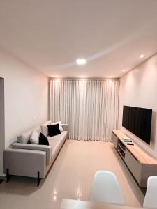 a living room with a couch and a flat screen tv at Villa Santiago in Manaus +2 photos