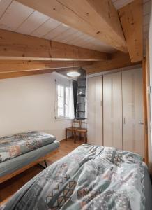 レンクにあるChalet Wassermandliの木製の天井が特徴のベッドルーム1室(ベッド2台付)