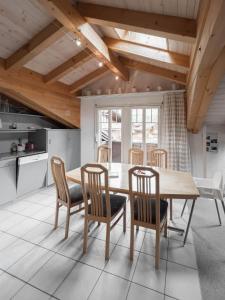 a dining room with a wooden table and chairs at Chalet Wassermandli in Lenk