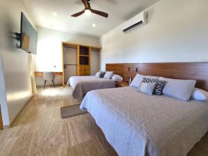 a bedroom with two beds and a ceiling fan at Pool Condo, just a few steps from the beach -north in Los Barriles +11 photos