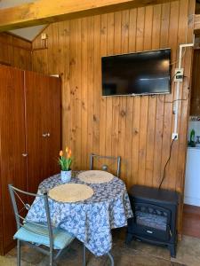 a table with two chairs and a television on a wall at Cabanas Klenner in Puerto Varas