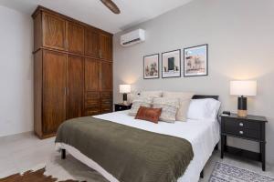 a bedroom with a large bed and a wooden cabinet at Walkable, Convenient in Downtown Los Barriles in Los Barriles +15 photos