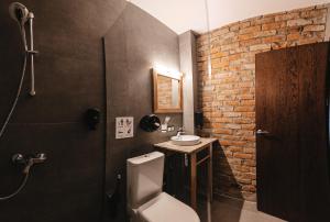 a bathroom with a toilet and a sink and a brick wall at Crama Mircesti 