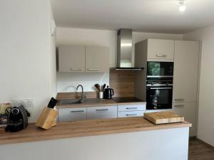 a kitchen with white cabinets and a counter top at Les Chalets de Montriond B101 By Avecoeur in Montriond