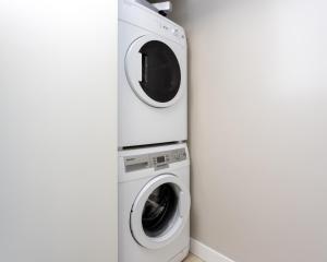 a washing machine and a dryer in a room at Hendrix Luxury Apartments by Corporate Stays in Edmonton