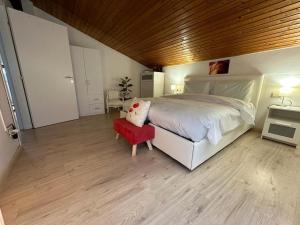 a bedroom with a large bed and a red chair at Plose Panorama House in Bressanone