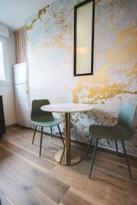 a table with two chairs and a mirror on a wall at LE GOLDEN Gare SNCF - Résidence calme in Laval