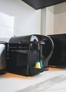 a black toaster oven sitting on top of a counter at LE GOLDEN Gare SNCF - Résidence calme in Laval