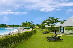 a park with chairs and tables and a beach at Natra Bintan, a Tribute Portfolio Resort in Lagoi