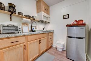 a kitchen with wooden cabinets and a stainless steel refrigerator at Enchanting Home In Ideal Downtown Location in Oklahoma City