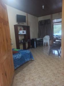 a bedroom with a bed and a dining room with a table at Arenal Jungla Lodge in San Ramón