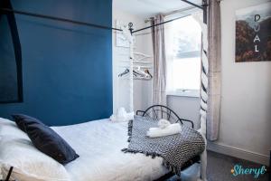 a bedroom with a bed with a blue wall at Liverpool City Grandeur by Sheryl - Close to City Center, Anfield Stadium and Airport with free business super fast fibre broadband in Liverpool