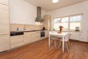 a kitchen with a white table and white chairs at Stadthaus mit 2 Schlafzimmern & Wohnzimmer mit Kamin - Kostenloser Privat-Parkplatz auf dem Grundstück in Leipzig