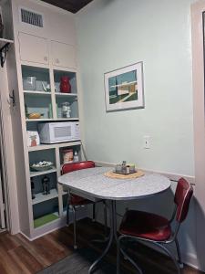 a kitchen with a table and two red chairs at The Cottage at Pineapple House in West Palm Beach