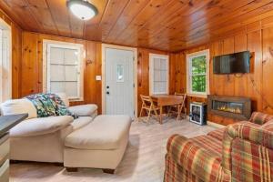 a living room with a couch and a tv and a fireplace at Paradise Lake Hidden Gem in Carp Lake