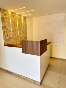a reception desk in a lobby with a stone wall at Humaita Pousada in Itacaré