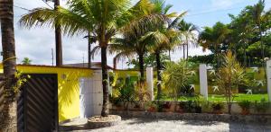 ペルイベにあるCantinho da Vovóの椰子の木と柵のある黄色い家