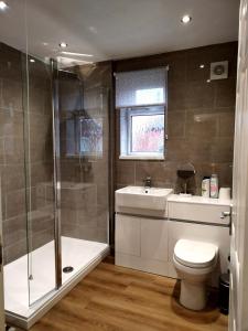 a bathroom with a shower and a toilet and a sink at Comfort Private Rooms in Three bedroom House in Bridgemary