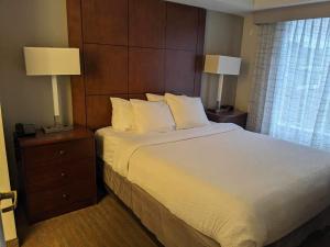 a hotel room with a large bed with two lamps at ReVi Columbus North in Columbus
