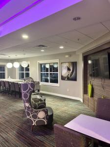 a waiting room with chairs and a table and a tv at ReVi Columbus North in Columbus