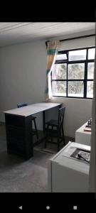 Zimmer mit einem Schreibtisch, einem Stuhl und einem Fenster in der Unterkunft Casa mami5 in Oaxaca de Juárez
