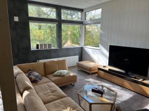 a living room with a couch and a flat screen tv at Kalamunda House Rusutsu in Rusutsu