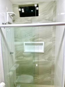 um chuveiro com uma porta de vidro na casa de banho em Humaita Pousada em Itacaré