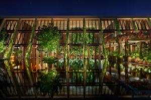 a building with potted plants on the side of it at The Riviera Maya EDITION at Kanai in Playa del Carmen