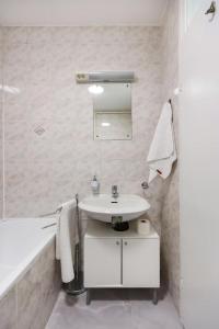 ein Badezimmer mit einem Waschbecken, einem Spiegel und einer Badewanne in der Unterkunft White & Bright Escape 1BDR apt in Zagreb