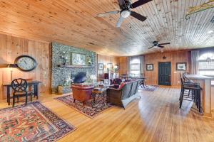 ein Wohnzimmer mit Holzwänden und einer Uhr an der Wand in der Unterkunft Countryside Cabin Rental about 10 Mi to Wadesboro! in Wadesboro