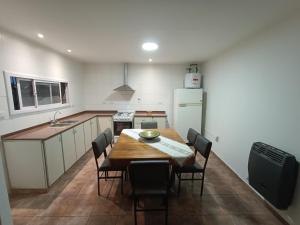 eine Küche mit einem Tisch und Stühlen sowie einem Kühlschrank in der Unterkunft Casa Romo in San Rafael