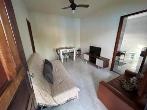 a living room with a couch and a tv at Casa na esquina da praia com quintal in Saquarema