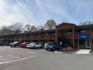 un edificio con auto parcheggiate in un parcheggio di SureStay Plus by Best Western Woodbury Inn a Woodbury