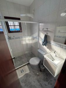 łazienka z toaletą i umywalką w obiekcie Casa na esquina da praia com quintal w mieście Saquarema