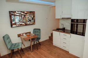 - une petite cuisine avec une petite table et des chaises dans l'établissement Passage apartment Subotica, à Subotica