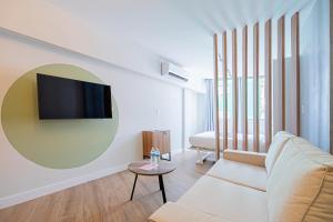 een woonkamer met een bank en een tv aan de muur bij Casa Ambar Apartments in Panama-Stad