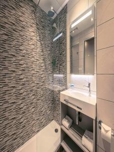 La salle de bains est pourvue d'un lavabo et d'une douche. dans l'établissement Best Western Marseille Aeroport, à Vitrolles